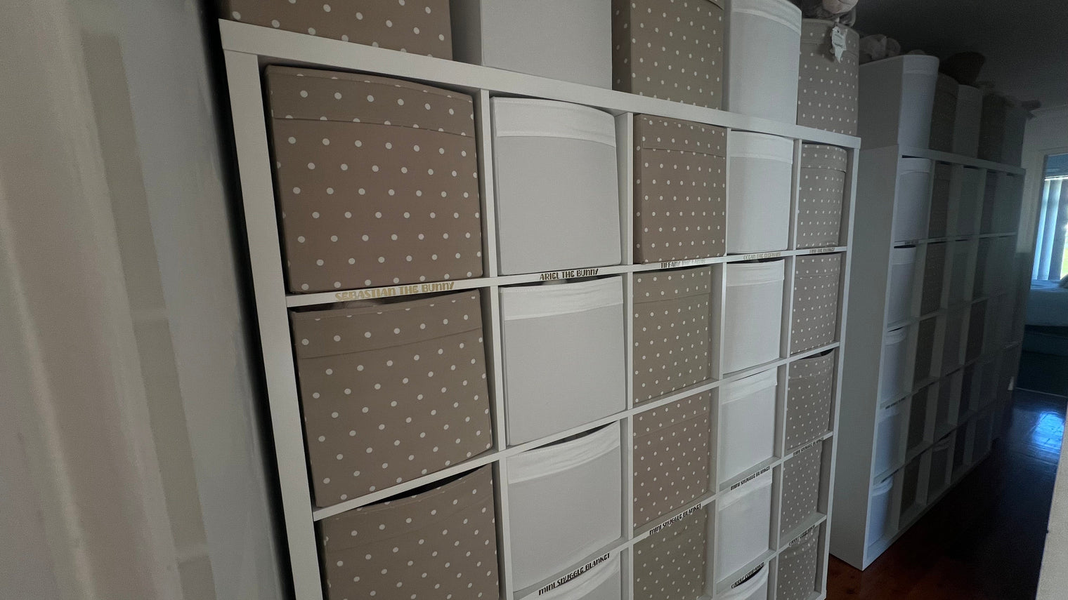 Organised storage of Cutesy Wootsy baby comforters and plush toys in a home-based business setup, showing neatly labelled bins for each character.