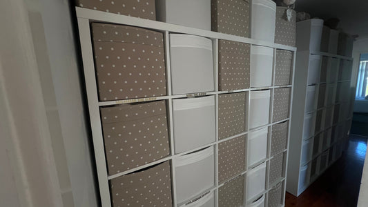 Organised storage of Cutesy Wootsy baby comforters and plush toys in a home-based business setup, showing neatly labelled bins for each character.