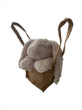 Load image into Gallery viewer, Cozy-beige coloured fluffy plush bunny head resting adorably on its paws, sitting propped up in a natural, brown hessian jute bag
